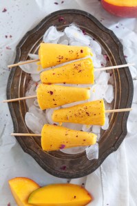 Greek Yogurt, maple syrup and fresh mangoes - that's all you need to make these refreshing mango lassi popsicles. Just add mango chunks or mango pulp, maple syrup, yogurt and cardamom to a high-speed blender and process into a smooth puree. Cover popsicle mold with lid and insert popsicle sticks. Freeze for couple hours and enjoy.